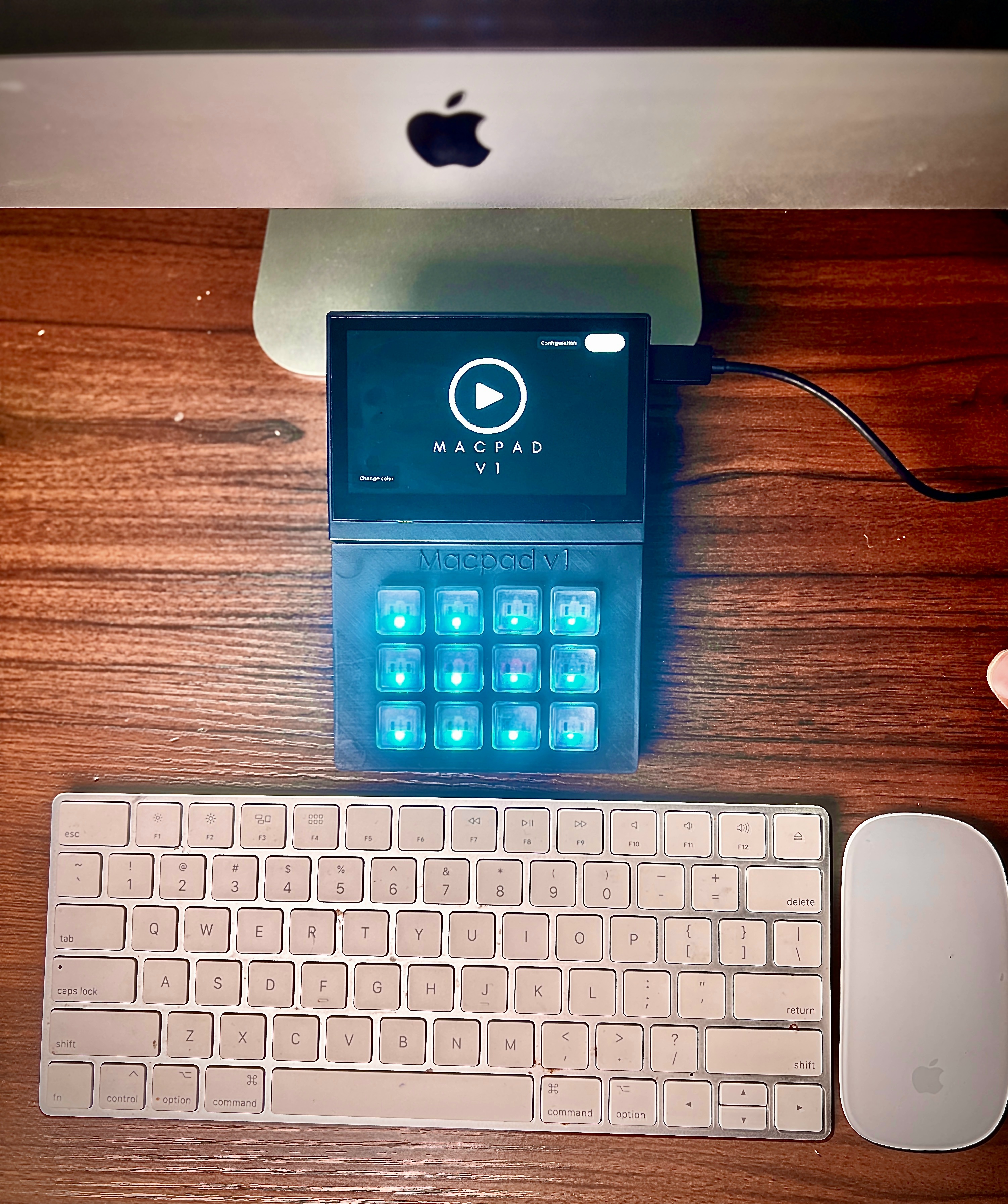 MacPad V1 macro keyboard - 4.3 inch LVGL touchscreen showing splash screen, 12 Cherry MX keys with cyan RGB backlighting, 3D-printed enclosure, connected to iMac