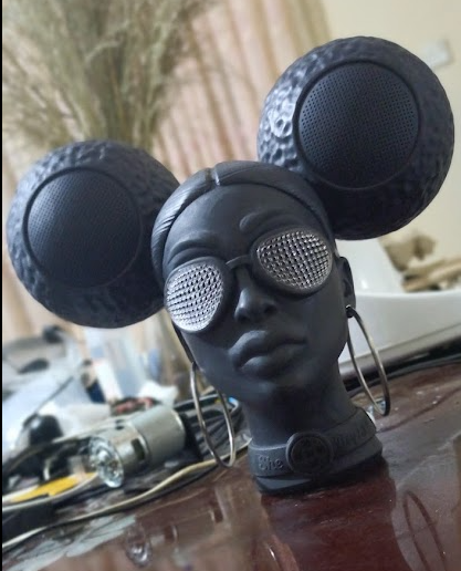 She Bops speaker - sculptural black mannequin bust with dual circular speaker drivers and mesh grille sunglasses